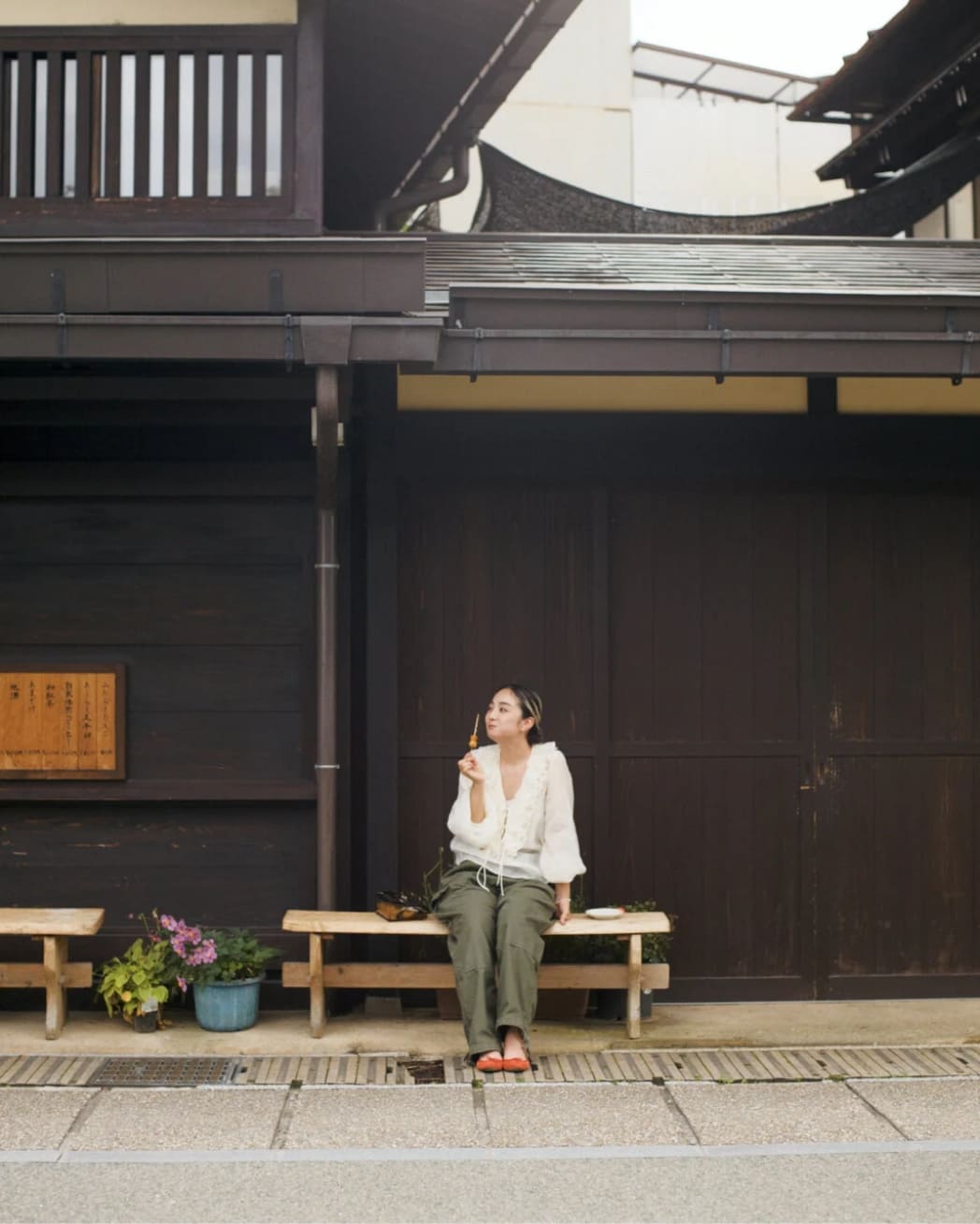 ベンチでお団子を頬張る女性の写真