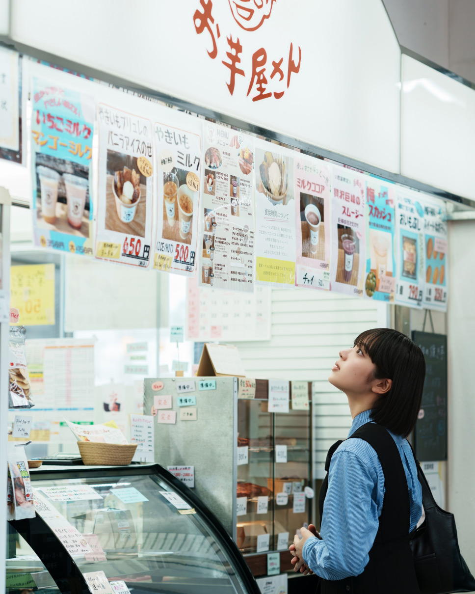 よっしーのお芋屋さんでメニューを見る朝日奈まおさん