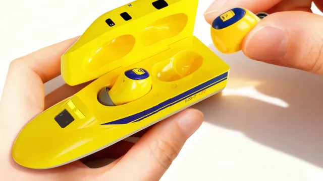 923形ドクターイエローT4型ワイヤレスイヤホンを手に持つイメージ